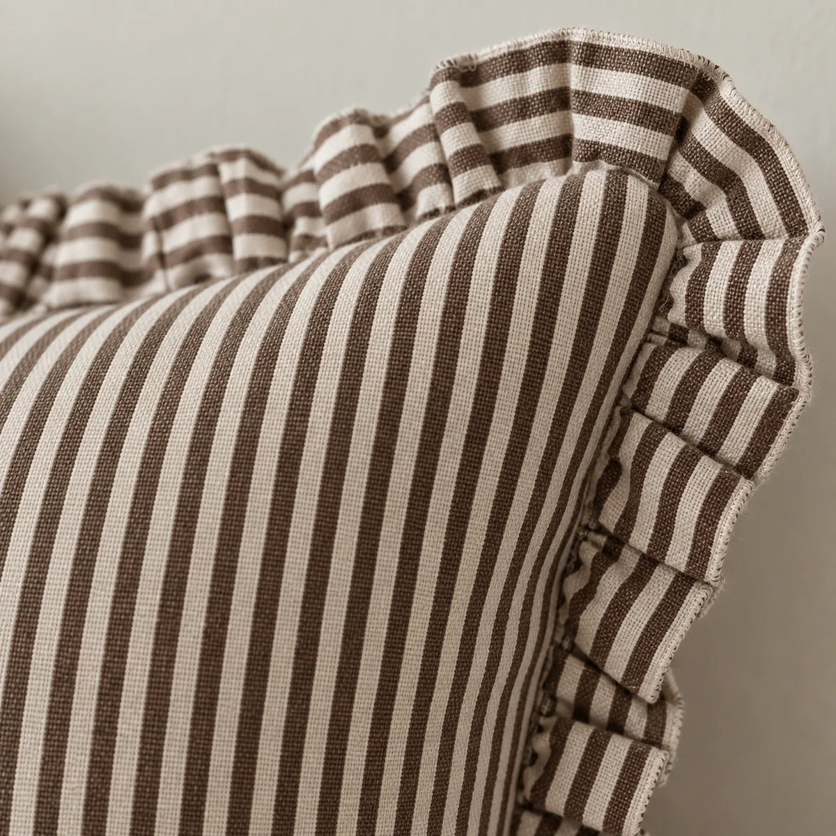 Close-up of Darcy chocolate brown pinstripe cushion cover fabric and ruffle edge
