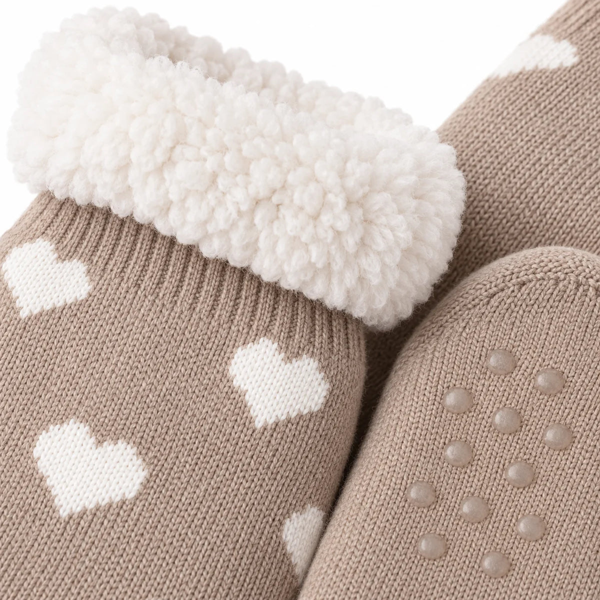 Close-up of taupe heart slipper sock knit, fleece lining and grip sole