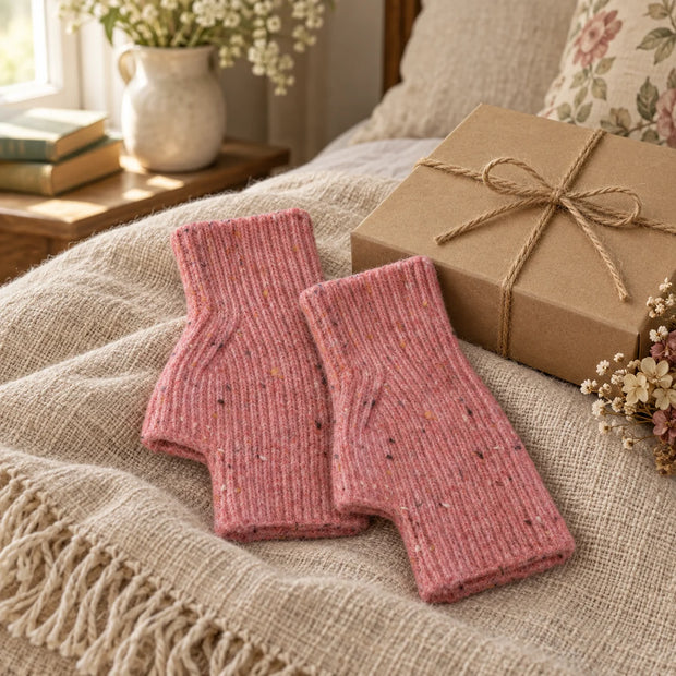 Pink speckle fingerless gloves styled beside a kraft gift box