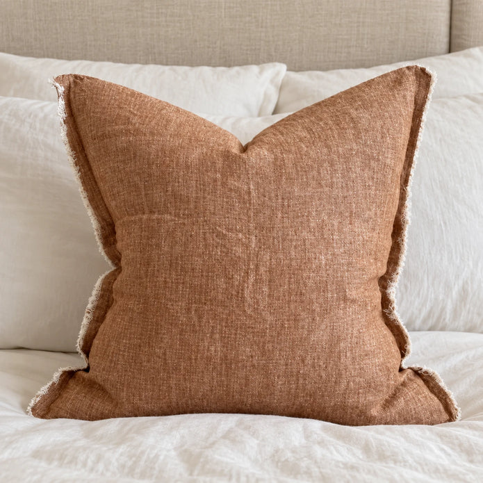 Ellenvale Esmee washed rust brown cushion cover styled on a bedroom bed