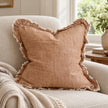 Ellenvale Hallie washed rust brown square cushion cover on an armchair