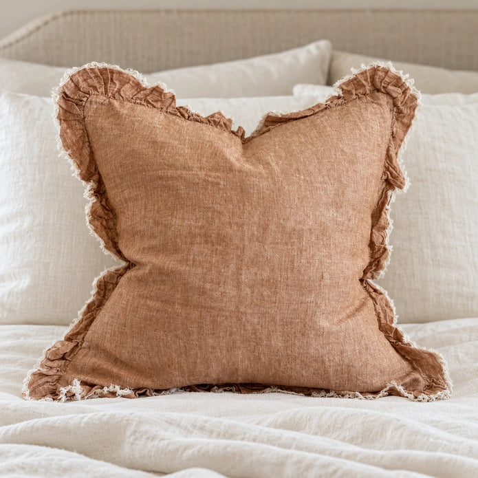 Ellenvale Hallie washed rust brown square cushion cover styled on a bedroom bed