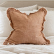Ellenvale Hallie washed rust brown square cushion cover styled on a bedroom bed