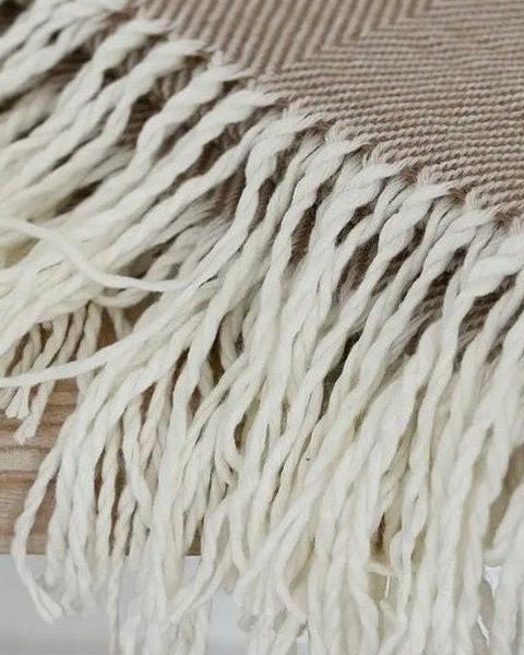 Beige herringbone throw blanket with brown tassels from Ellenvale Trade, soft furnishings for cozy home decor.