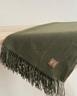 Olive green Della fine knit tasselled throw blanket by Ellenvale Trade, soft furnishings for cozy home decor.