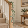 Eucalyptus And Red Berry Garland on an oak stair rail.