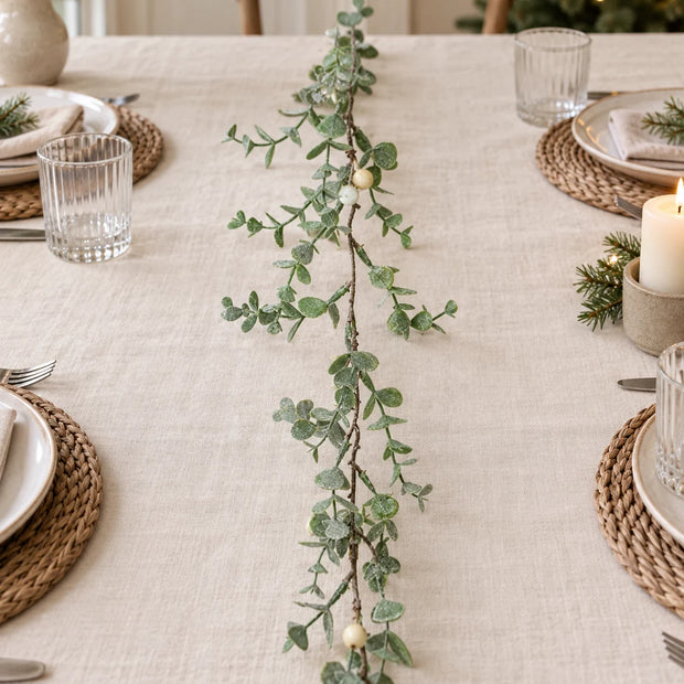Eucalyptus Leaf And White Berry Garland along a linen Christmas table.