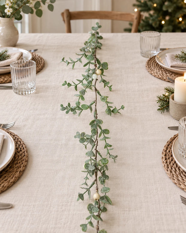 Eucalyptus Leaf And White Berry Garland along a linen Christmas table.