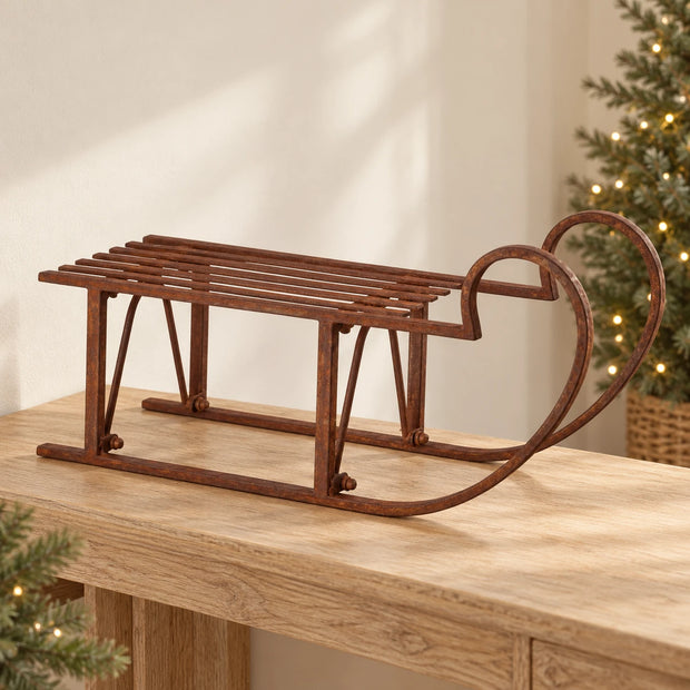 Extra Large Rustic Metal Christmas Sleigh Decoration — Single empty sleigh on long pale oak console with soft cream wall and distant pine tree