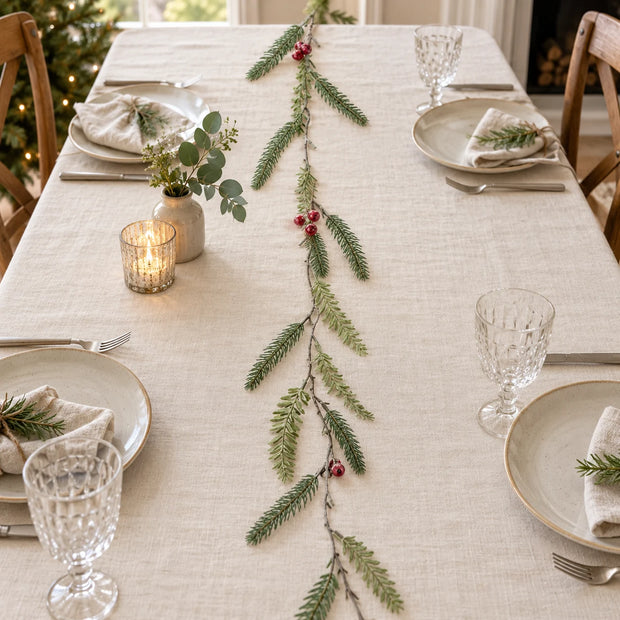 Green Fir And Red Berry Garland along a linen Christmas table.