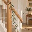 Green Fir And Red Berry Garland on an oak stair rail.