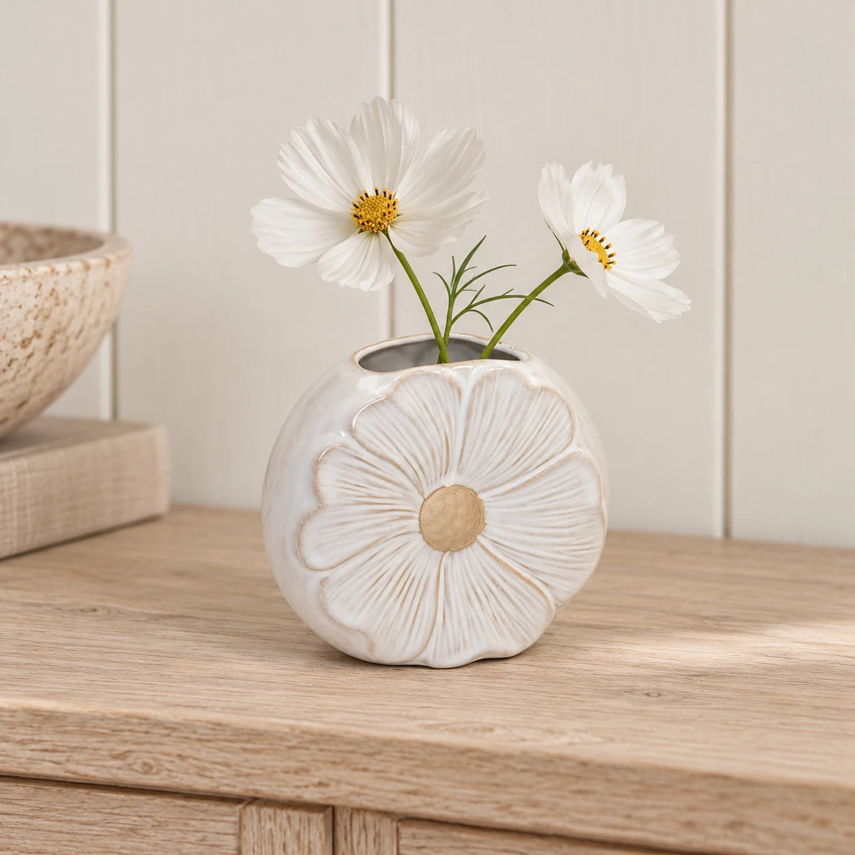 Small flower detailed vase styled with two white cosmos stems on an oak console