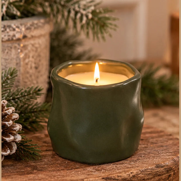 Olive green Satchville sculpted candle used as home decor with a forest-green finish, showcasing a textured, artistic design.