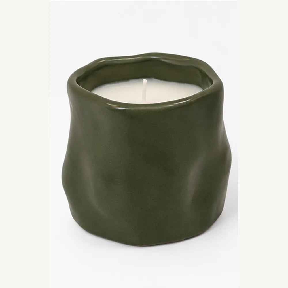 Forest green sculpted ceramic candle front view showing organic shape and white wax