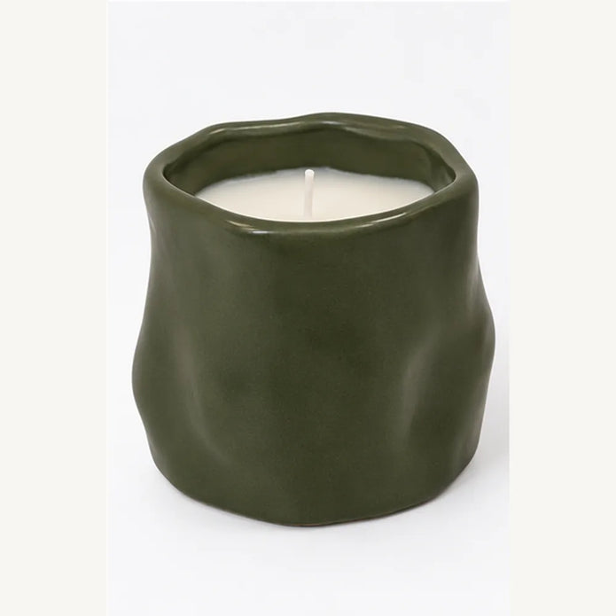 Forest green sculpted ceramic candle front view showing organic shape and white wax