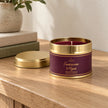 Small tin candle with frankincense and myrrh scent, perfect for Christmas, by Shearer Candles, displayed on a console table.