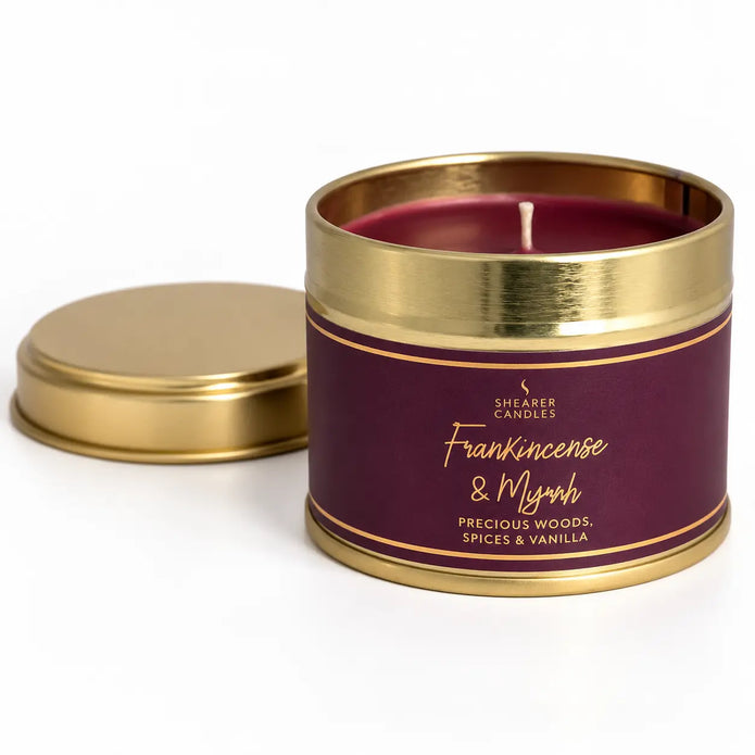 Small tin candle from Shearer Candles with Frankincense and Myrrh scent, featuring festive Christmas packaging.