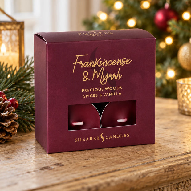 Shearer Candles Frankincense and Myrrh tealights in burgundy packaging styled beside a Christmas tree