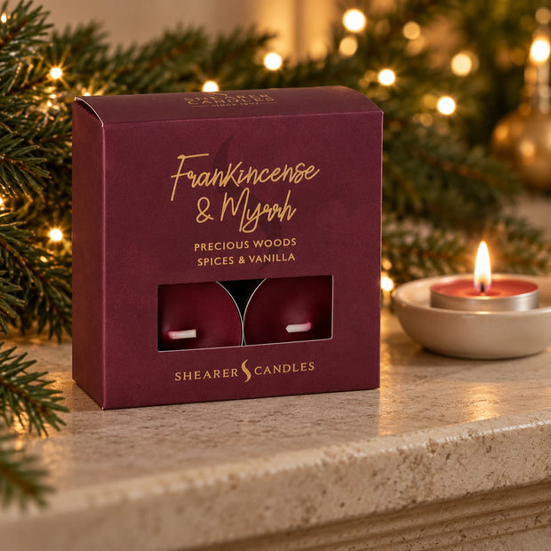 Frankincense and Myrrh tealights box on a stone mantel beside a lit burgundy tealight