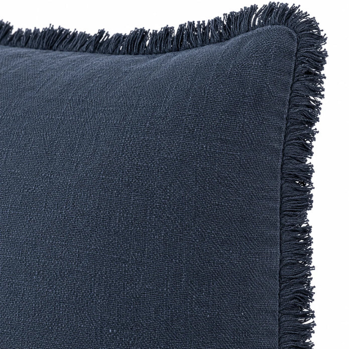 Close-up of the navy blue cushion cover's matte woven fabric and edge seam against white.
