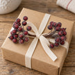 Frosted berry mini stem on a wrapped Christmas gift