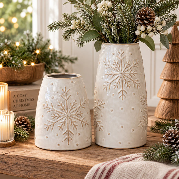 Medium and large frosted snowflake porcelain vases displayed together in Christmas styling with evergreen foliage and white berries; sizes sold separately