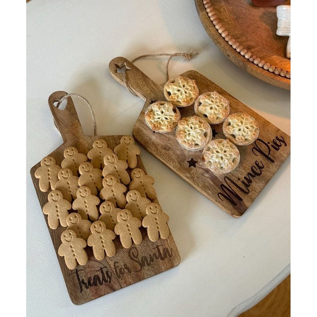Two wooden cutting boards with baked goods on a white surface
