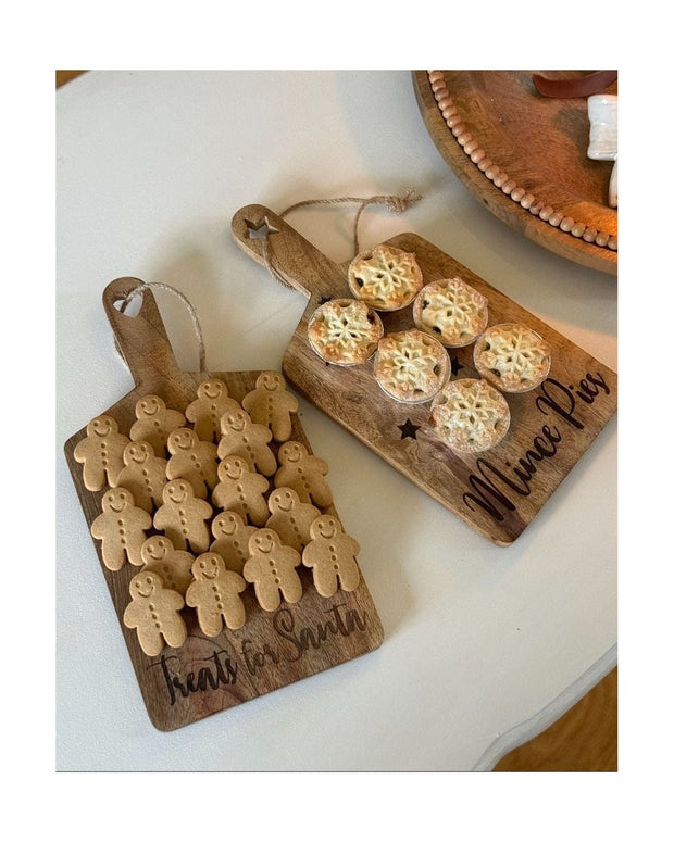 Two wooden cutting boards with baked goods on a white surface