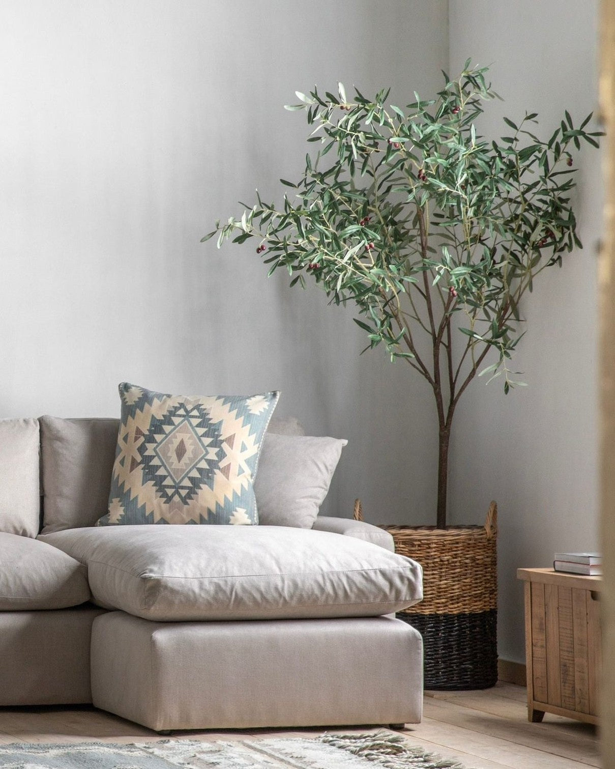 Extra large artificial faux olive tree by Gallery Direct, natural-looking green leaves and sturdy trunk in a decorative garden setting.