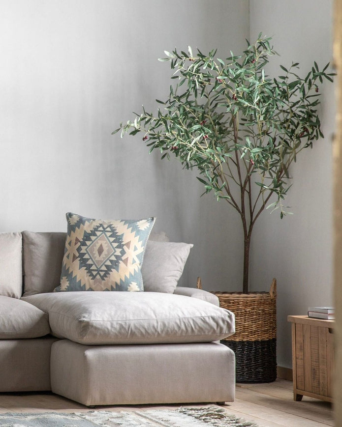 Extra large artificial faux olive tree by Gallery Direct, natural-looking green leaves and sturdy trunk in a decorative garden setting.