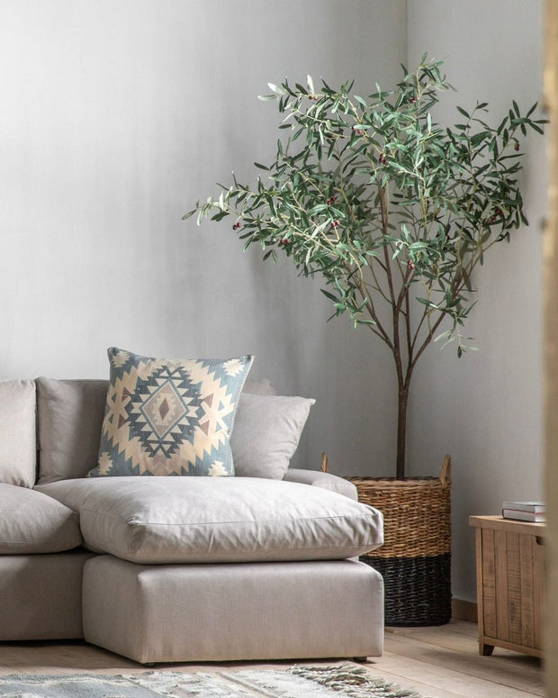Extra large artificial faux olive tree by Gallery Direct, natural-looking green leaves and sturdy trunk in a decorative garden setting.