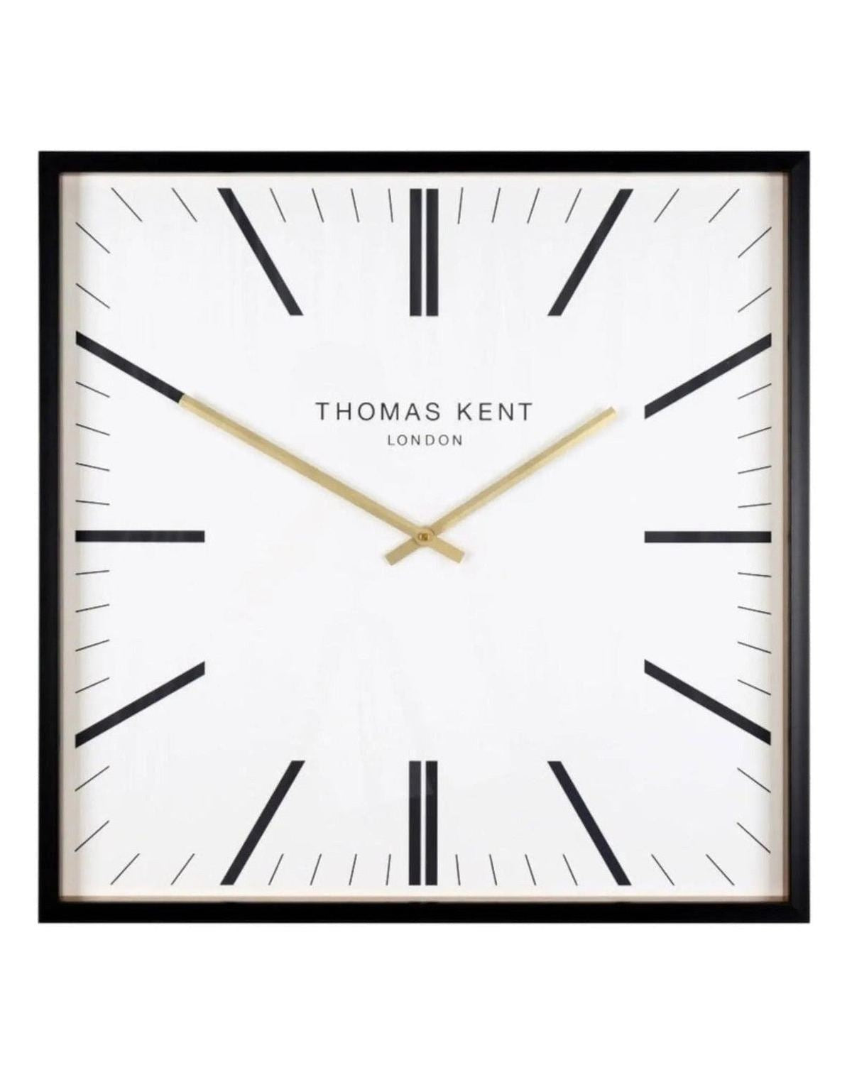 White Thomas Kent Garrick 16-inch wall clock with black Roman numerals and hands, mounted on a plain wall.