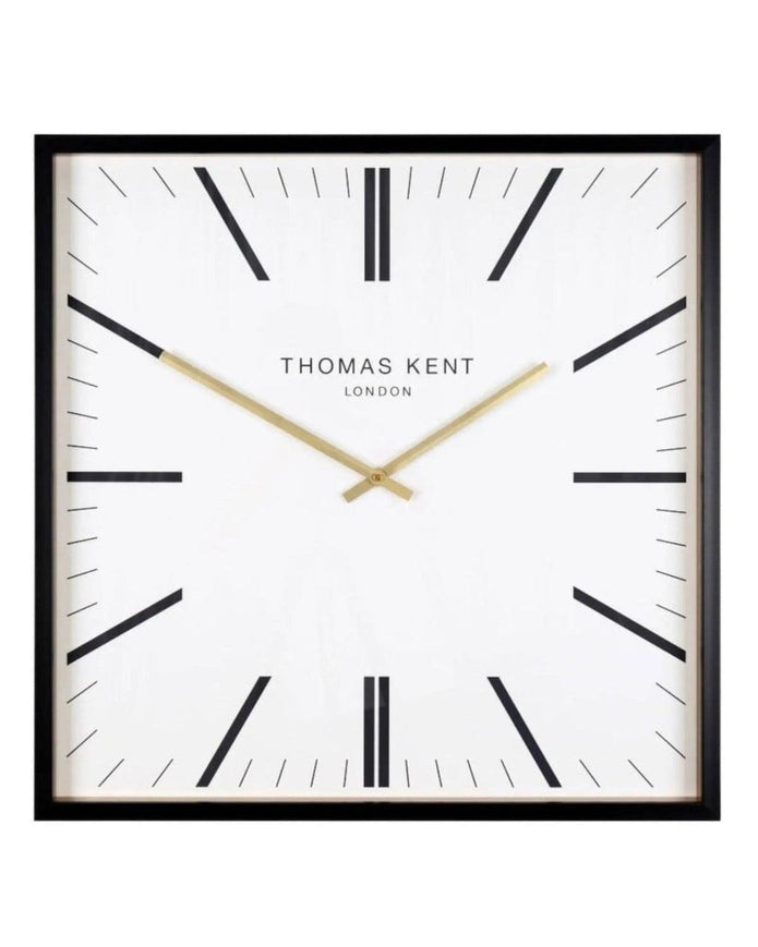 White Thomas Kent Garrick 16-inch wall clock with black Roman numerals and hands, mounted on a plain wall.