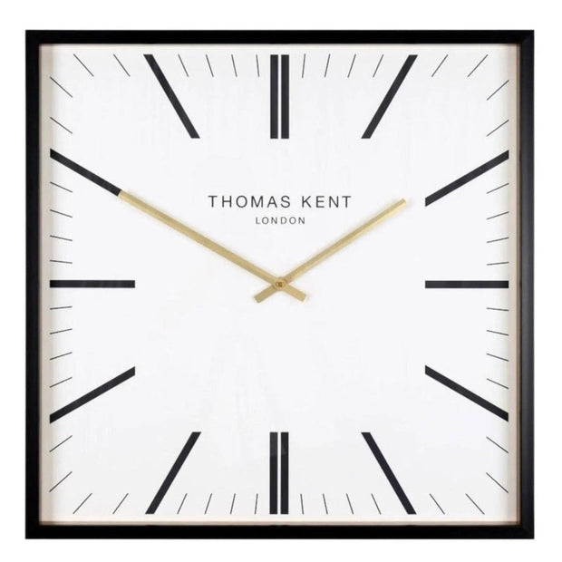 White Thomas Kent Garrick 16-inch wall clock with black Roman numerals and hands, mounted on a plain wall.