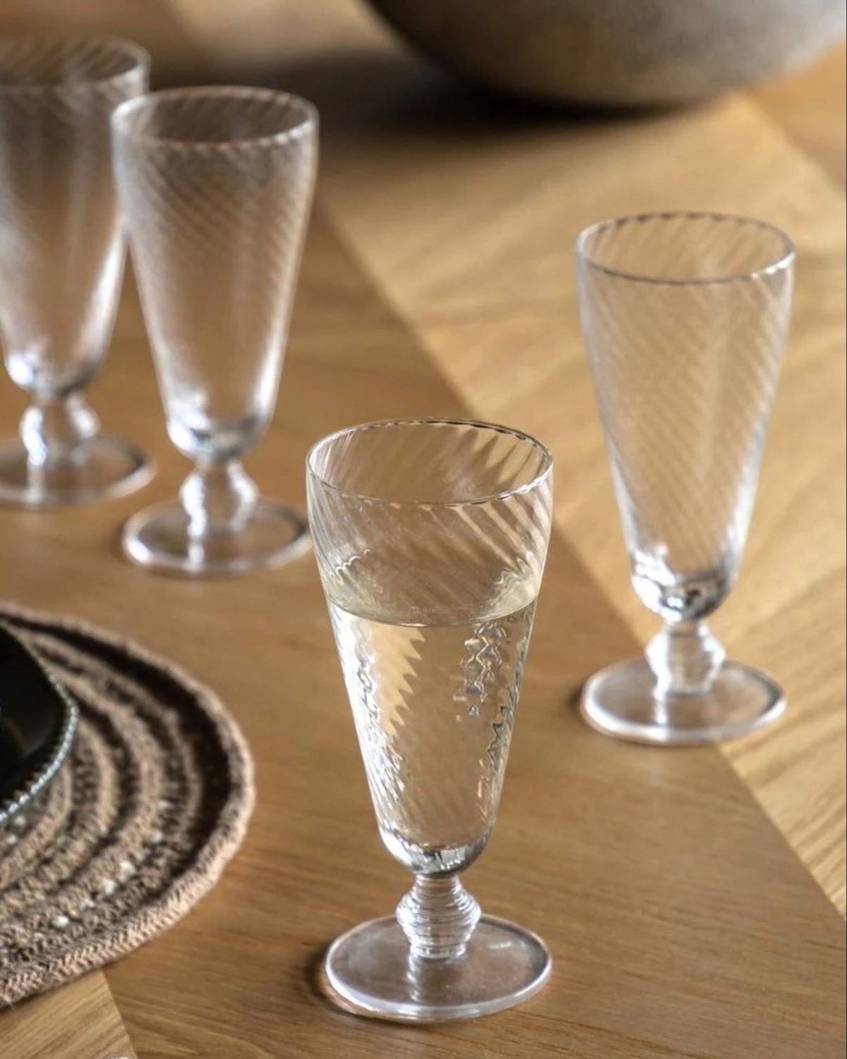 Set of four clear glass swirl flute glasses for elegant kitchen and dining use by Gallery Direct.