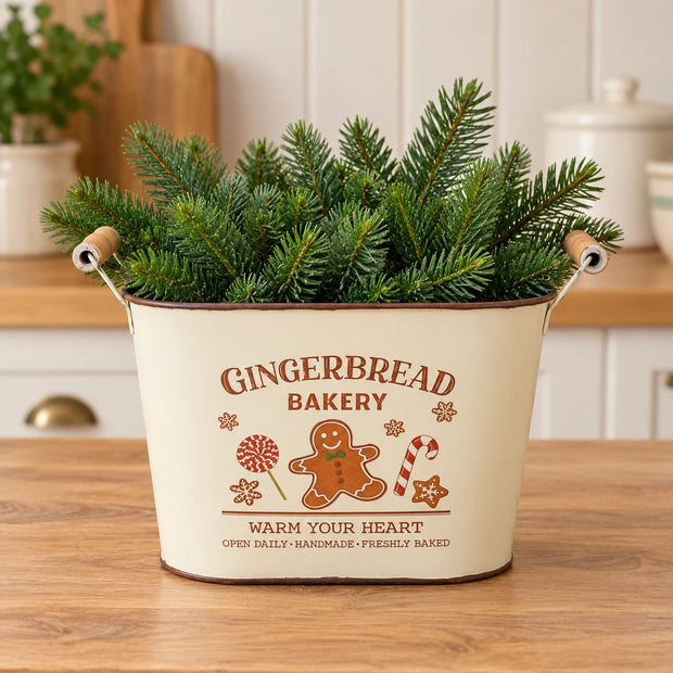 Cream Gingerbread Bakery oval planter filled with fir greenery in a Christmas kitchen