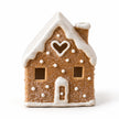 Heart-window gingerbread house tealight holder with white icing details on a white background