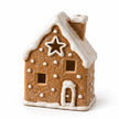 Star-window gingerbread house tealight holder with white icing details on a white background