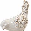 Close-up of the ceramic bird ornament's raised feather pattern and glossy ivory glaze