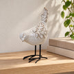 Ivory glazed ceramic bird ornament styled beside neutral books on a bright shelf