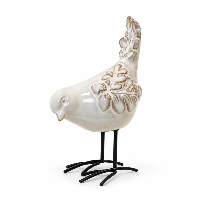 Glazed ceramic bird ornament with raised feather detail and black metal feet on white