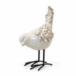Glazed ceramic bird ornament with raised feather detail and black metal feet on white