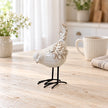 Textured ceramic bird ornament beside a cup of tea on a pale kitchen table