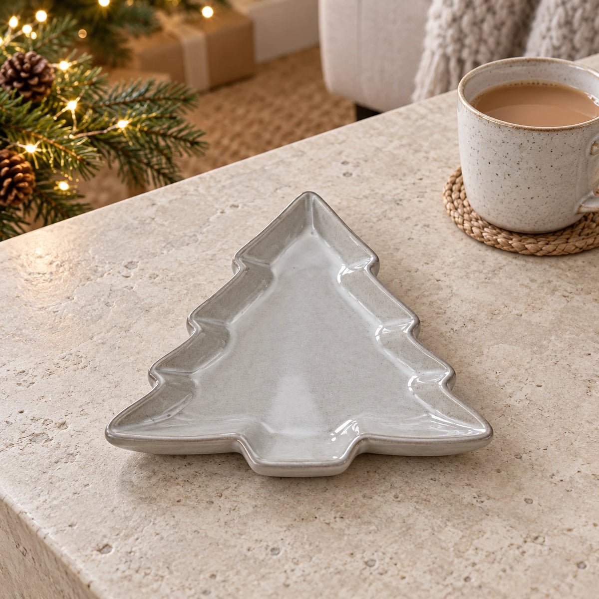 Glazed ceramic tree dish lying flat, on a stone coffee table beside tea