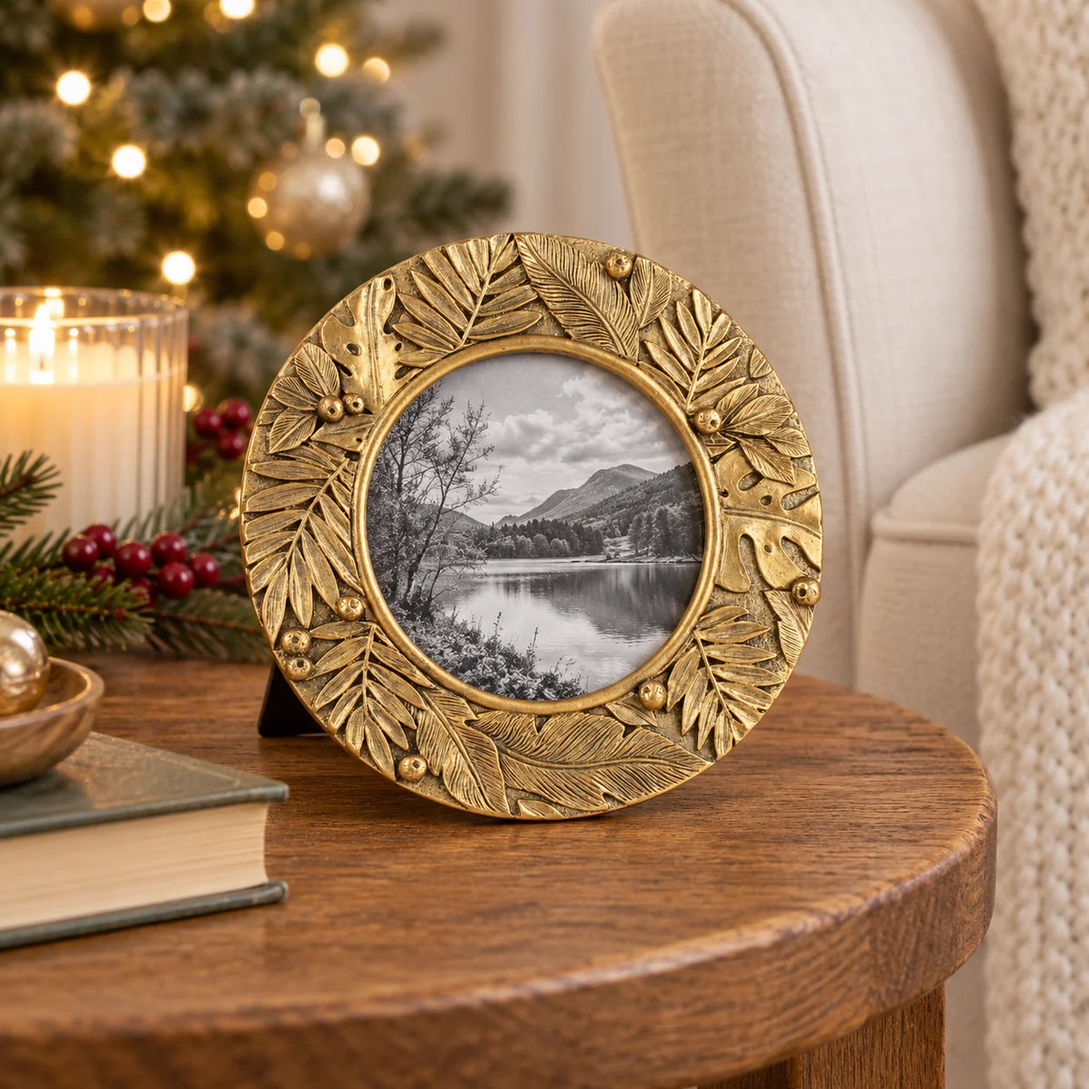 Gold leaf botanical round photo frame by Originals International Ltd on a side table