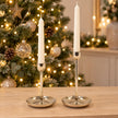 Small 16cm and large 21cm gold metal candlestick holders together with ivory candles and sparkling Christmas lights; holders sold separately