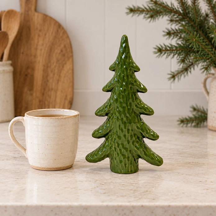 Green ceramic Christmas tree ornament by Satchville displayed on a kitchen scale