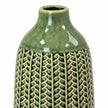 small green ceramic vase close-up showing glossy green glaze and cream leaf-patterned detailing on white