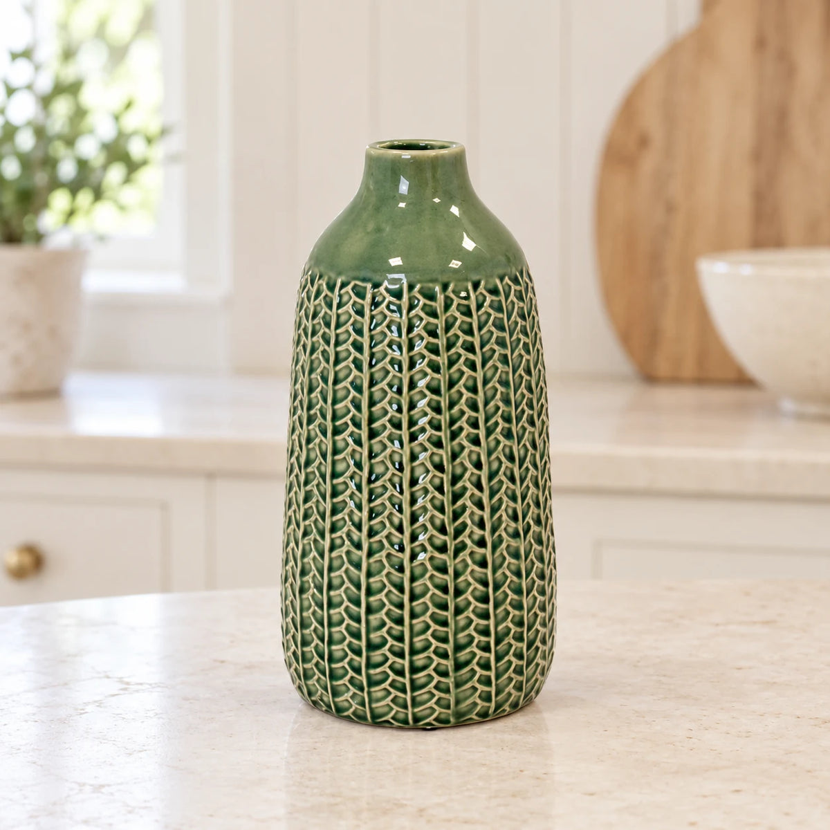 small green ceramic vase empty on a pale stone kitchen counter