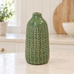 small green ceramic vase empty on a pale stone kitchen counter